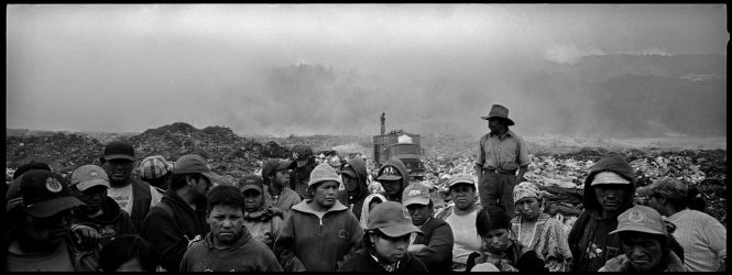 Workers in a garbage dump in Quetzaltenango, Guatemala wait to hear about a planned vocational training center that would teach them to do something other than earn a living by sifting through refuse for food and recyclables.
