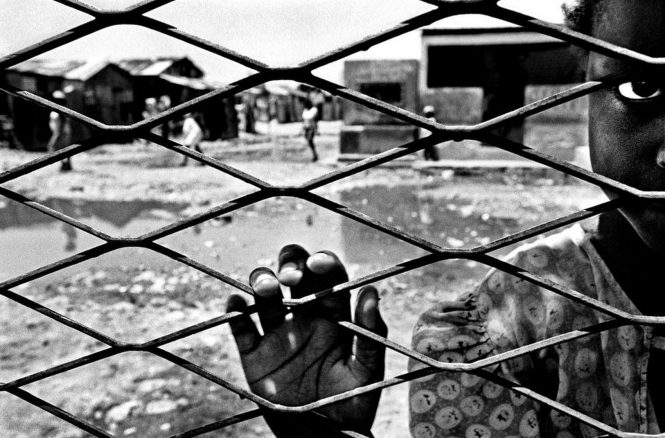 In the center of Cite Soleil, Haiti's largest slum, a relief agency operates a small, tidy school with limited capacity. Those children lucky enough to attend get an education and a meal each day. A fence separates this oasis of learning and nourishment from the slum where residents, such as this young girl, contend with backed up sewage, garbage and rats, never knowing when her next meal is coming.